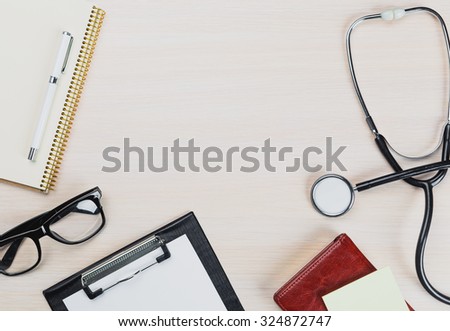 Stethoscope, clipboard on wooden background