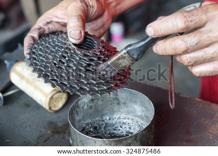 hand of a mechanic cleaning a bicycle cassette