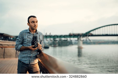 Photographer thinking about composition, holding old medium format camera
