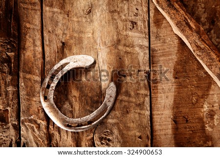 Shiny old lucky horseshoe on a rustic wood background with copyspace and a diagonal wood bar across the top corner, overhead view