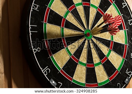 The darts isolated on wooden background Royalty-Free Stock Photo #324908285