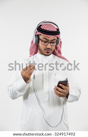 Arab man using mobile and listening music on headphones