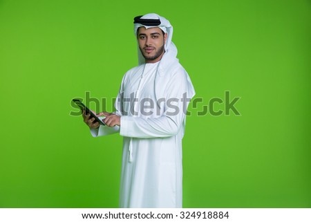 Portrait of Emirati businessman using digital tablet