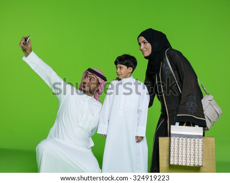 Arab family taking selfie using mobile camera
