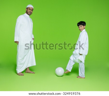 Arab father with son playing football