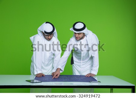 Emirati businessmen reviewing blueprint