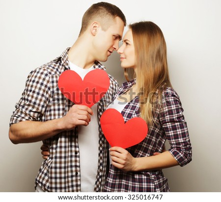 Love, family and people concept: Happy couple in love holding red heart.
