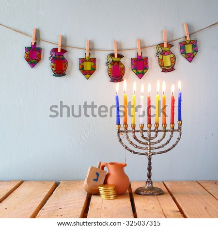 low key image of jewish holiday Hanukkah with menorah (traditional Candelabra) and wooden dreidels (spinning top).  