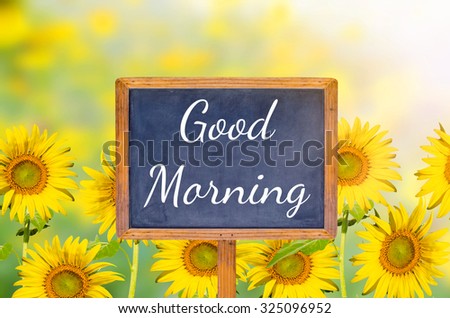 Good morning on blackboard with sunflower background