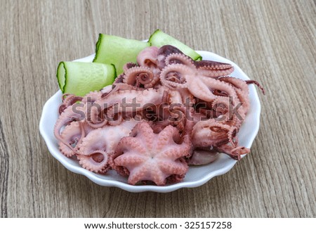 Marinated baby octopus in the bowl on wood background