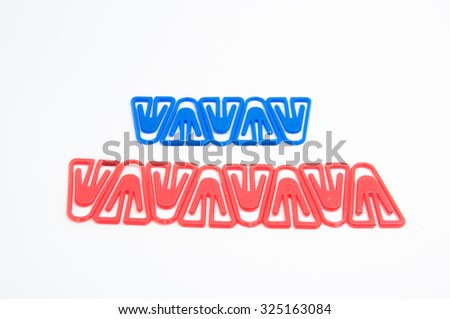 Plastic paper clips in art arranged on white background. -stock photo
