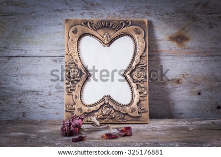 Still life with frame, roses on rusty steel board background