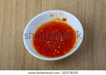 Hot chili sauce on the wood background