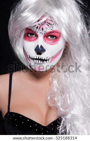 Portrait of a woman with green eyes and white hair on the face image of the skull. woman in the image of the dead man's bride on the feast of All Saints. Beautiful woman with make-up for Halloween 