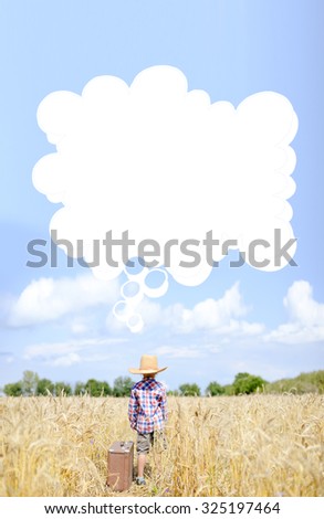 Picture of kid in straw hat standing beside valize in wheat field. Little boy in plaid shirt with thought bubble on summer sky countryside background.