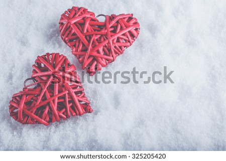 Two beautiful romantic vintage red hearts together on a white snow winter background. Love and St. Valentines Day concept.