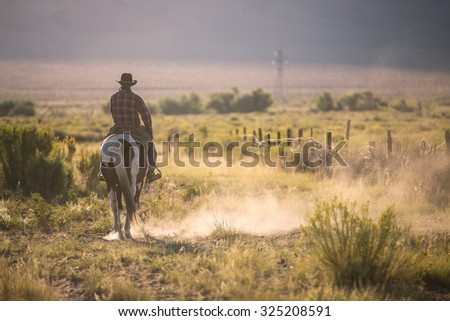 Cowboys riding a horse over the mountains 