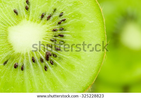 Slices of kiwi fruit on kiwi background. Royalty-Free Stock Photo #325228823