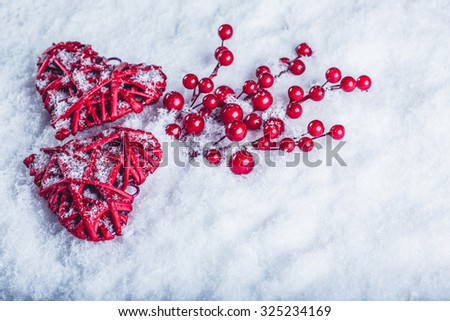 Two beautiful romantic vintage red hearts with mistletoe berries on a white snow winter background. Christmas, love and St. Valentines Day cozy concept.