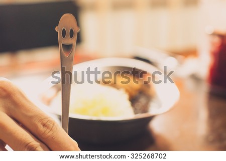 Smiling Shape Spoon with food behind it. conceptual for good mood and eating well.