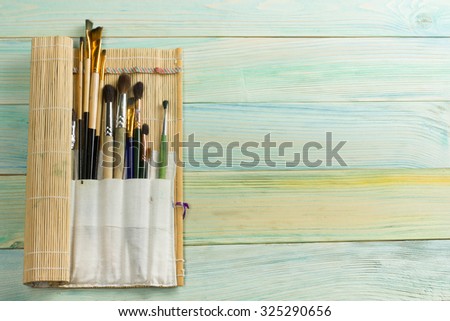 Artistic, artist, art. Used artist paintbrushes mastehin on wood background. Back to school, copy space. Education background.