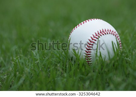The Baseball ball standard hard cork inner size diameter 7.28 CM hand sewing made from leather and weight 130 - 150 grame, isolated on green grass.