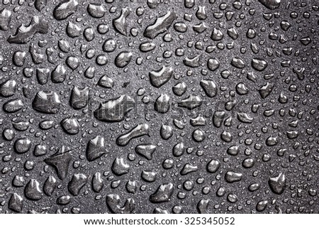 Water bubbles on black surface texture.