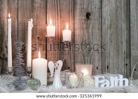 White candles, Christmas tree, angel and Faith by rustic antique wooden background