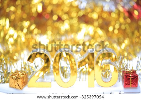 Golden 2016 3d icon with gift box in the christmas ornaments golden tinsel defocused blur backgrounds
