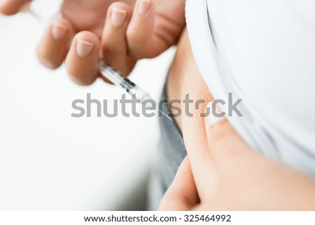 medicine, diabetes, glycemia, health care and people concept - close up of woman with syringe making insulin injection to himself at home Royalty-Free Stock Photo #325464992