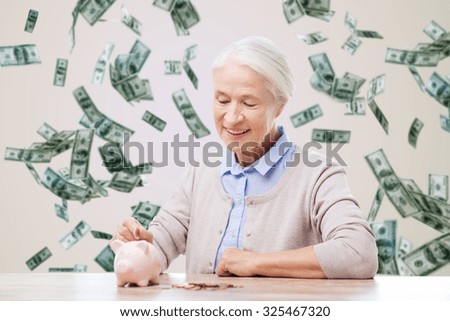 savings, finances, annuity insurance, retirement and people concept - smiling senior woman putting coins into piggy bank over money rain background