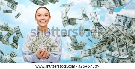 business, money, finance, people and banking concept - smiling businesswoman with heap of dollar cash money over blue sky background
