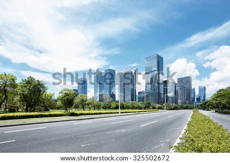 asphalt road of a modern city with skyscrapers as background Royalty-Free Stock Photo #325502672