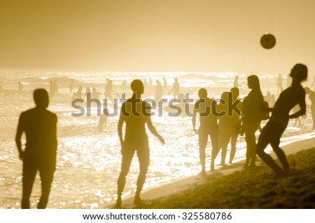 Silhouettes of Brazilians playing keepy uppy beach football on the shore of Ipanema Beach in Rio de Janeiro, Brazil