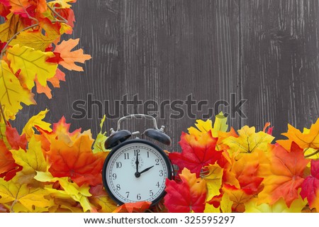 Autumn Leaves Background, Autumn Leaves and Alarm Clock with grunge wood with space for your message
