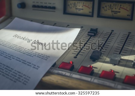 Audio console in the radio studio and the text of "breaking news" lorem ipsum