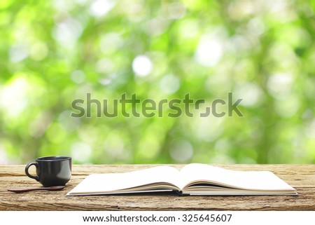 Notebook  and coffee in black cup on wooden table