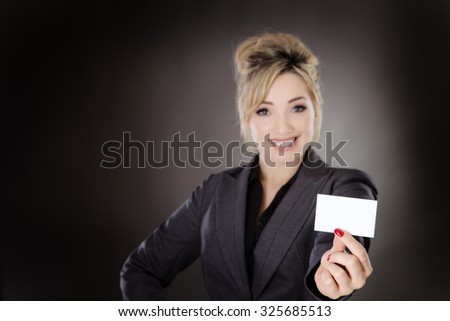 business woman holding up a businesscard shot in the studio on a gray background.
