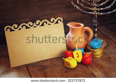 image of jewish holiday Hanukkah with menorah (traditional Candelabra) and wooden dreidels (spinning top) with empty card for adding text
