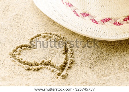 sign heart on sand with hat, relax concept.