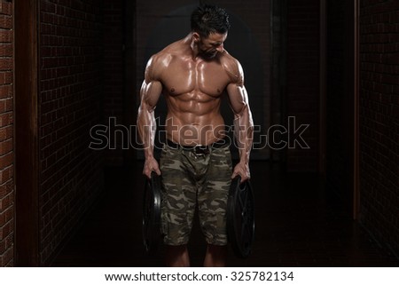 Fit Athlete Working Out Trapezius With Weights