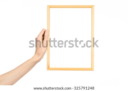 House decoration and Photo Frame topic: human hand holding a wooden picture frame isolated on a white background in studio