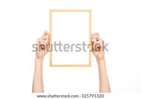 House decoration and Photo Frame topic: human hand holding a wooden picture frame isolated on a white background in studio