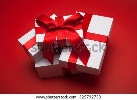 Gift with red bow on red background
