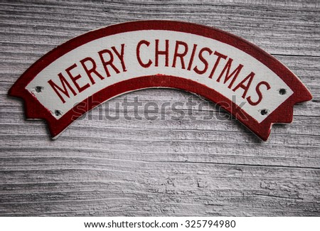 Merry Christmas words on banner over old wood surface. Retro style