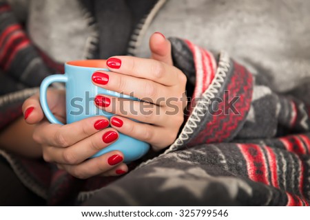 female hands holding a mug of hot beverage Royalty-Free Stock Photo #325799546