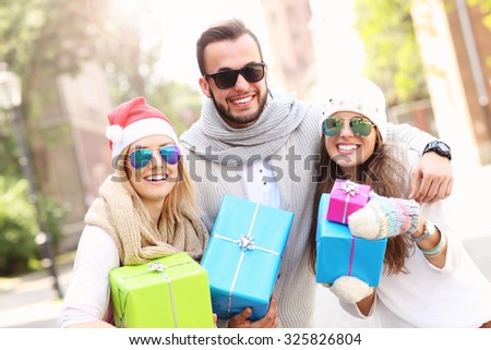 A picture of group of friends holding presents and smiling to the camera