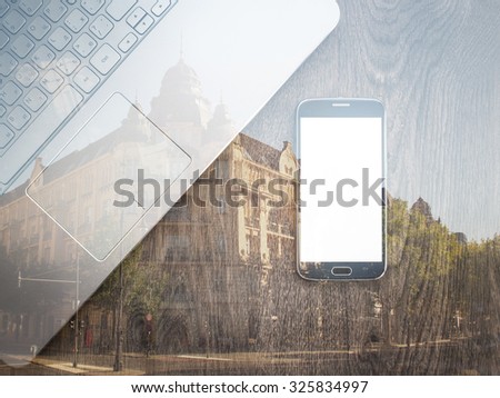 Double exposure of smartphone with Blank screen with laptop on table. City street on background. Wooden texture