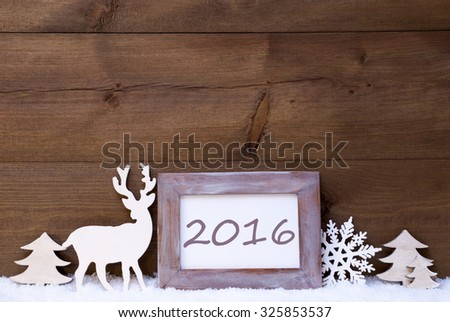 Christmas Card With Shabby Chic Picture Frame On White Snow. Text 2016 For Happy New Year. Christmas Decoration Like Snowflake, Tree And Reindeer. Vintage, Wooden Background.