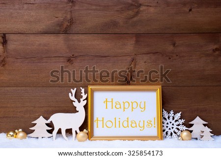 Christmas Card With Picture Frame On White Snow. English Text Happy Holidays. White Decoration Like Snowflake, Tree, Golden Balls And Reindeer. Vintage, Wooden Background